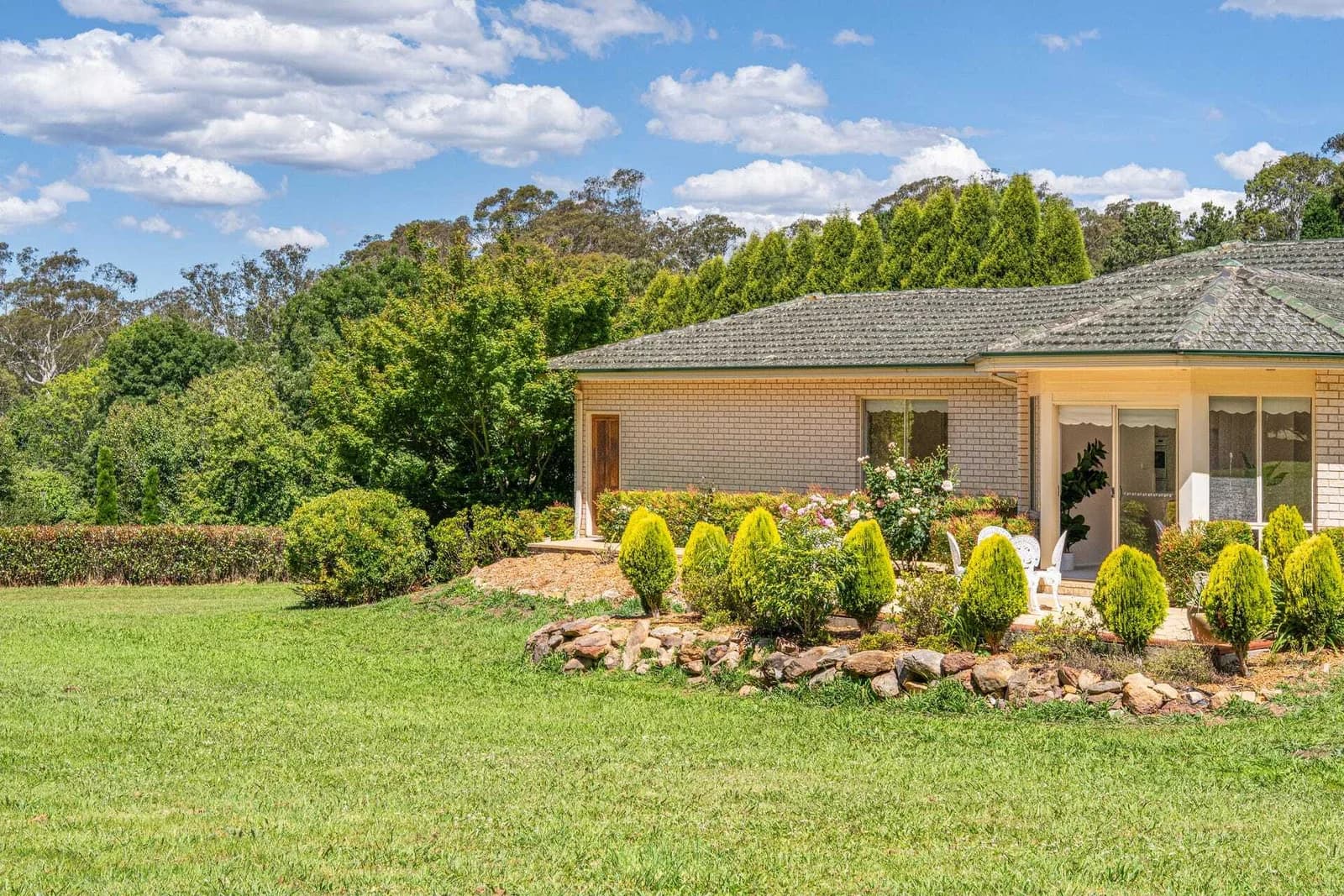 Current side and rear brick elevation beside landscaped lawn