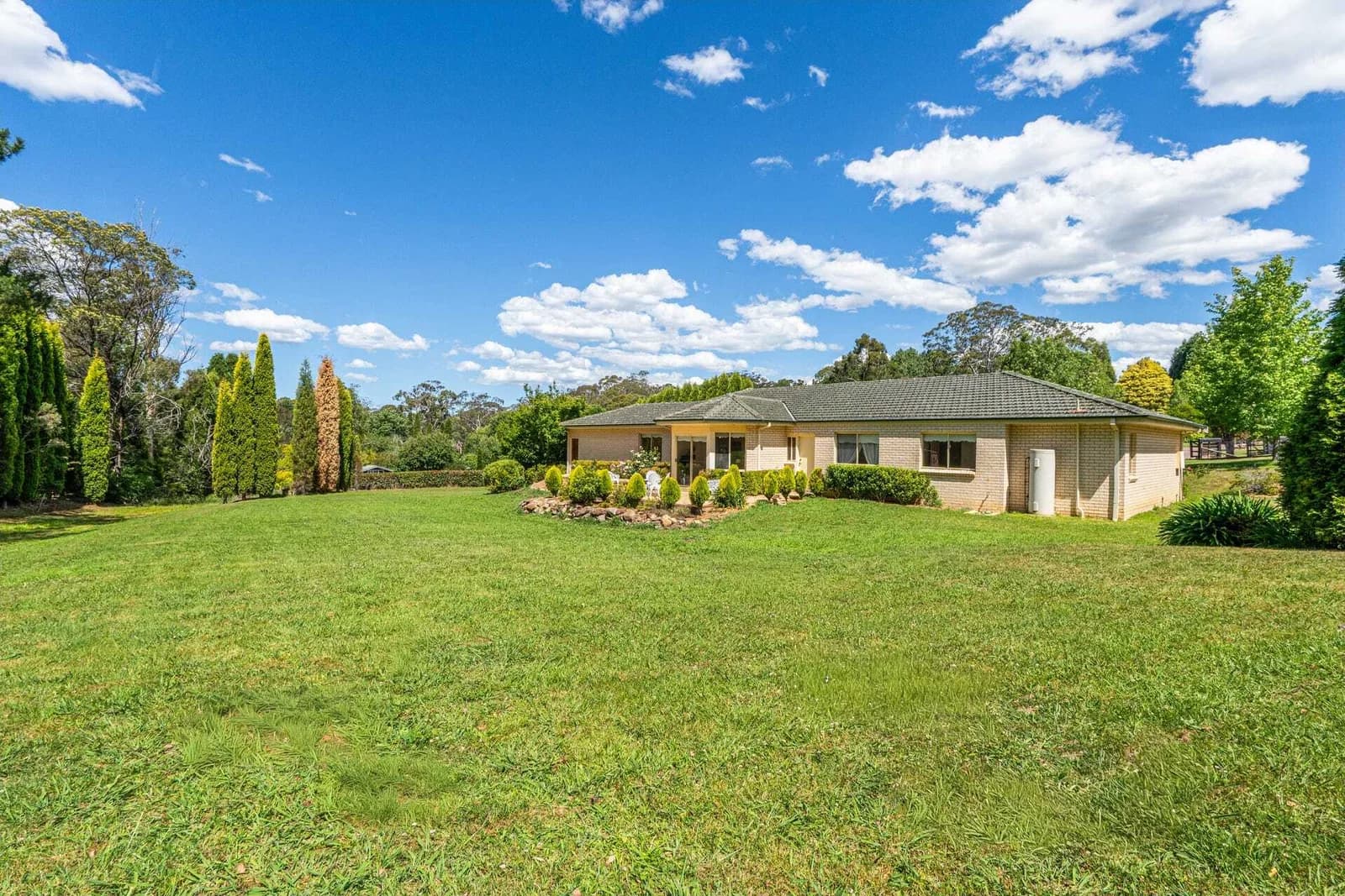 Current home viewed across the broad lawn and established boundary planting